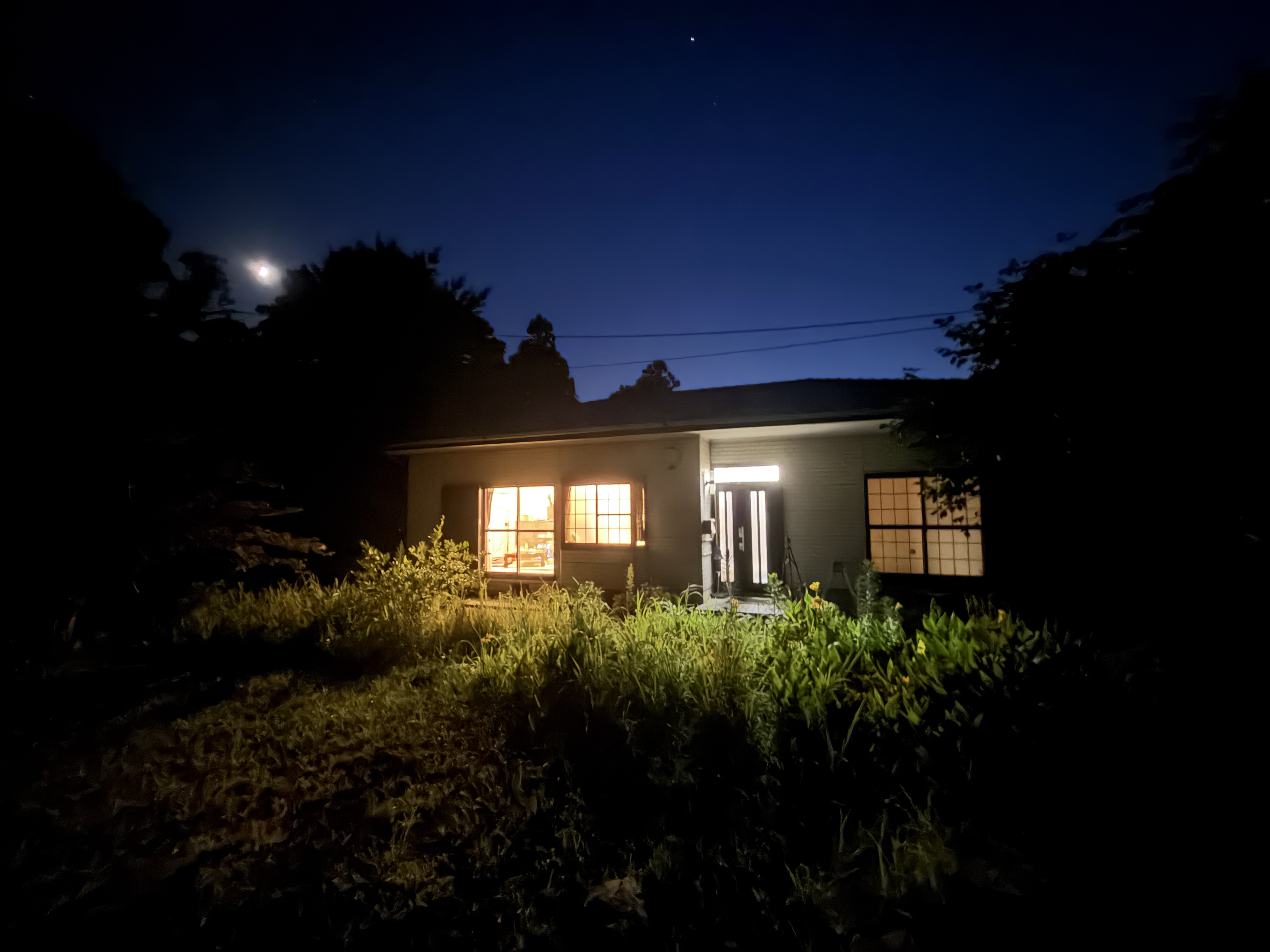 灯りだけがともる、夜の家の外観